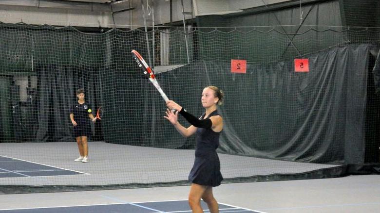 Penn State Altoona student-athlete Lexi Colaianni playing tennis in an indoor facility.